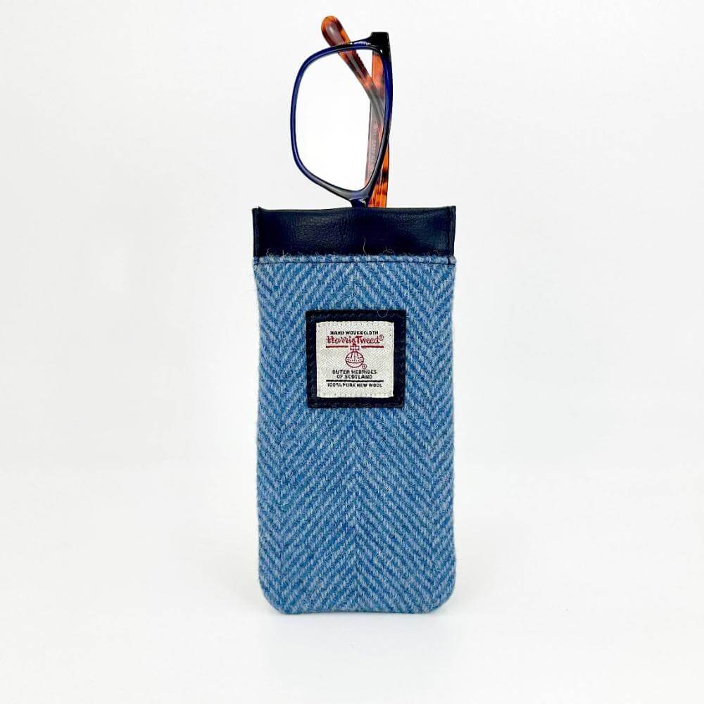 Glasses peeking out from the top of a Harris Tweed sleeve in herringbone sky blue fabric.