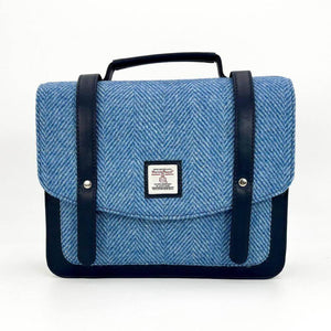 Front view of Harris Tweed messenger bag in sky blue with herringbone pattern and faux leather straps.