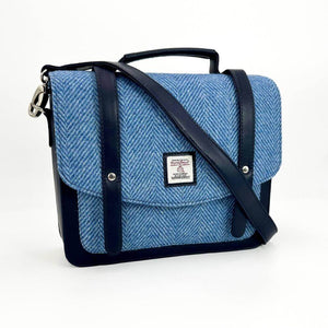 Harris Tweed messenger bag with crossbody strap attached, styled diagonally over the front flap.