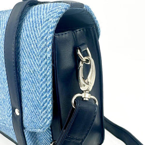 Close-up of silver metal clip attaching the adjustable strap to the Harris Tweed messenger bag.