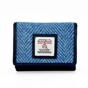 Front view of Harris Tweed trifold purse in sky blue with signature label and navy trim.