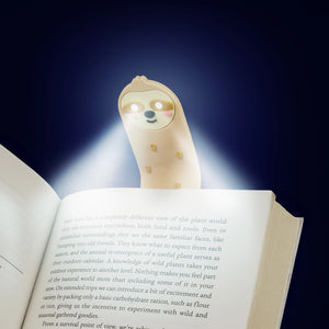 LED Sloth Reading Light glowing in the dark – illuminating book pages during nighttime reading.