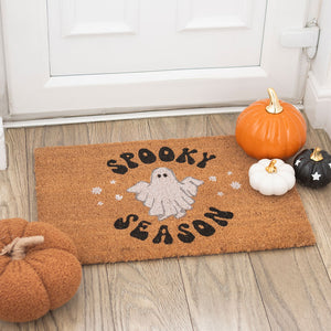 Spooky Season Halloween doormat at front door with ghost design and decorative pumpkins.