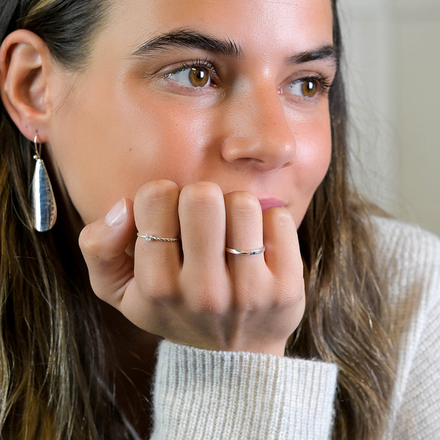 Woman wearing sterling silver twist ring with tiny CZ crystal.