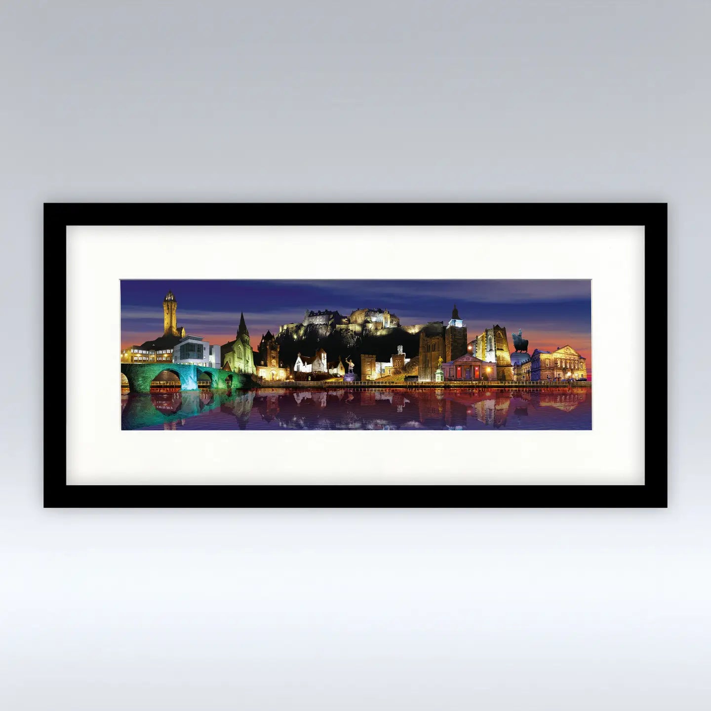 Framed Stirling Night mounted print featuring a panoramic view of Stirling’s landmarks illuminated at night.
