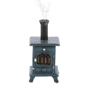 Front view of stove-shaped incense burner with smoke – rustic blue incense cone holder styled like a vintage wood burner.