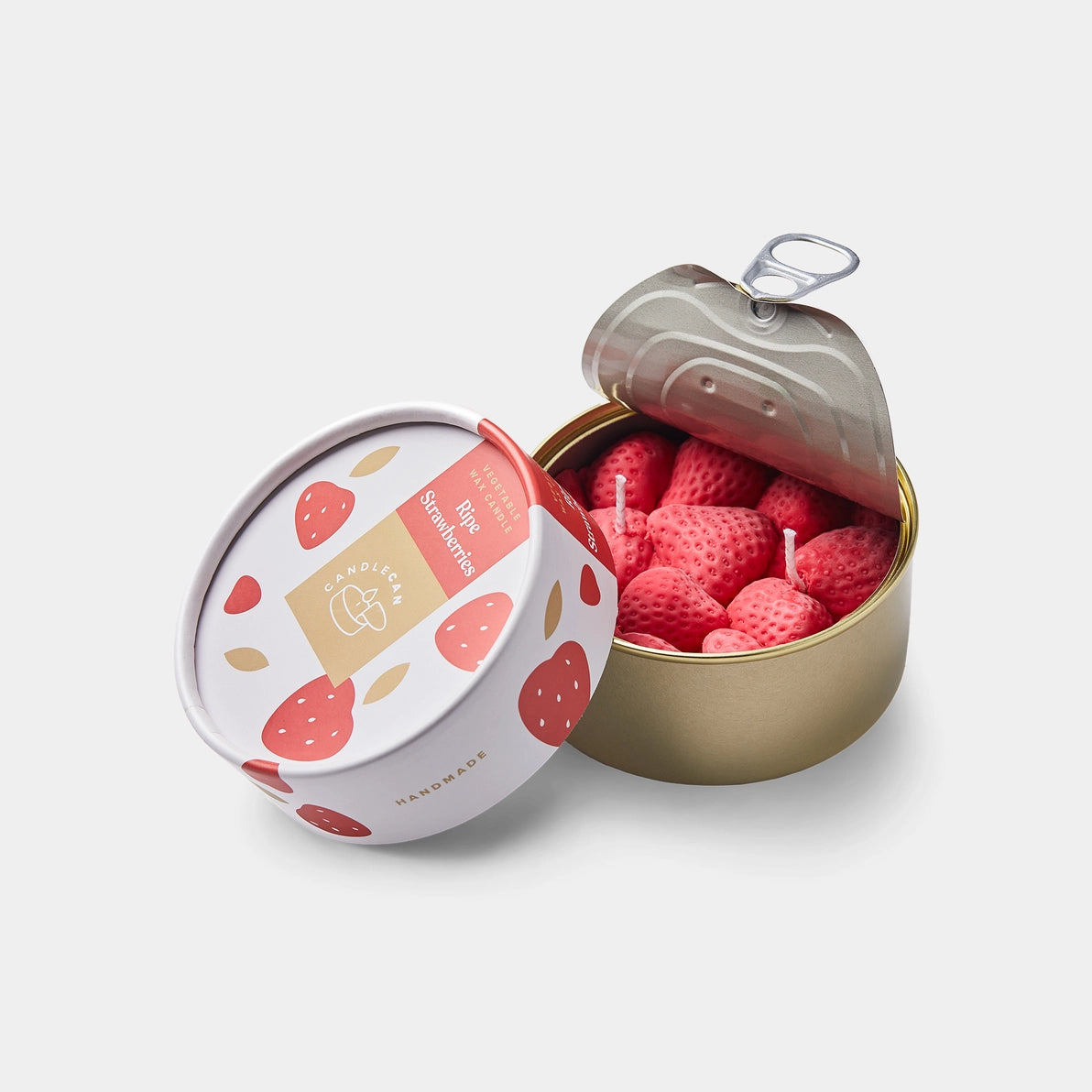 Strawberry Scented Candle in a tin, opened to reveal realistic wax strawberries with wicks, next to its illustrated strawberry-themed lid.