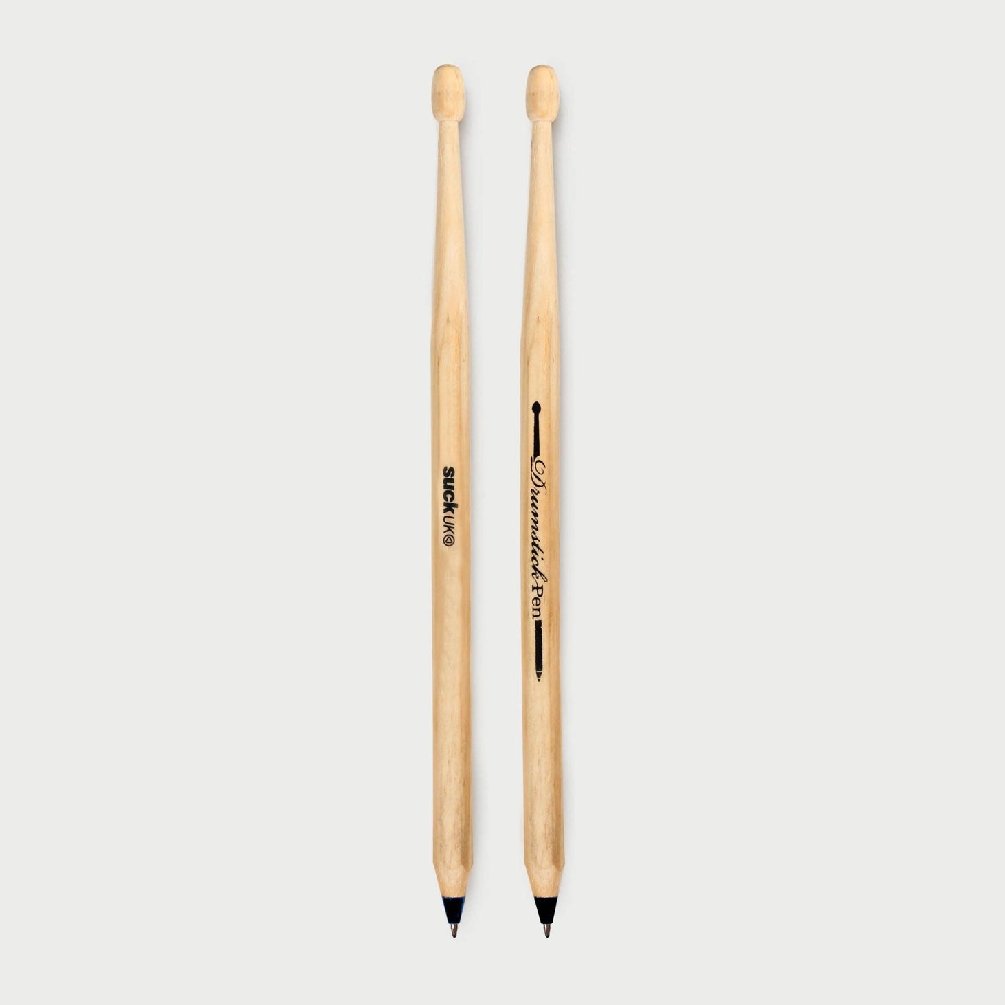 Overhead view of two drumstick pens placed side by side on a neutral background, showing both SUCK UK and Drumstick Pen branding.