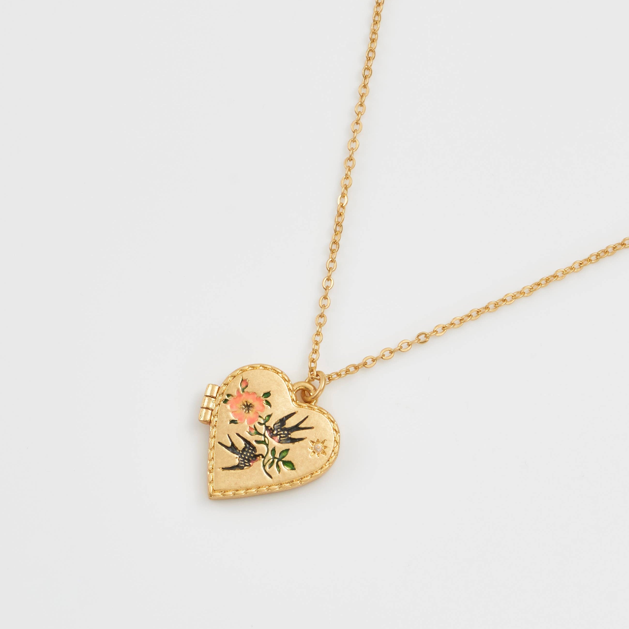 Gold-plated heart locket necklace featuring a hand-painted enamel design of two swallows and pink flowers on a fine chain.
