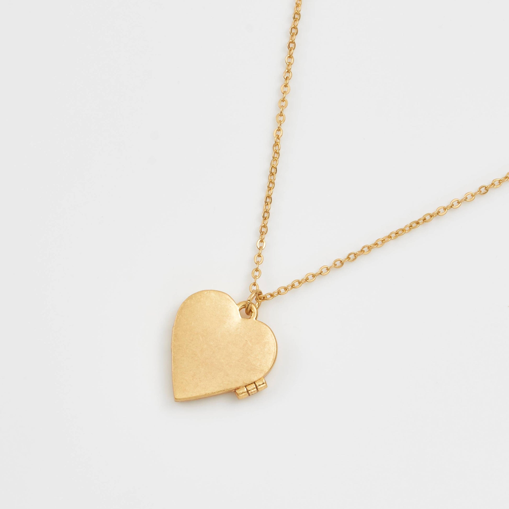 Back view of gold-plated heart locket necklace showing smooth brushed finish on a delicate chain.