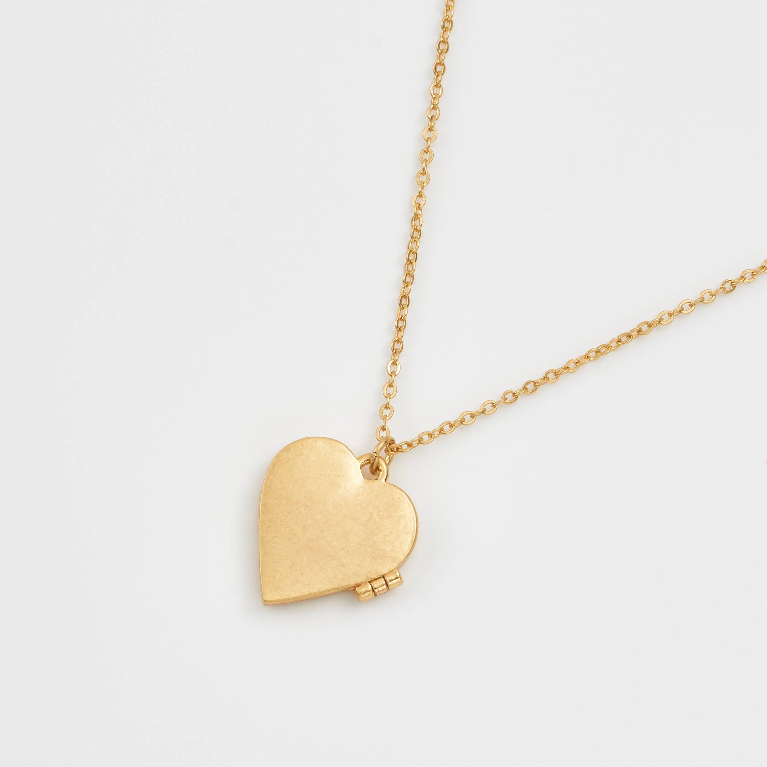 Back view of gold-plated heart locket necklace showing smooth brushed finish on a delicate chain.