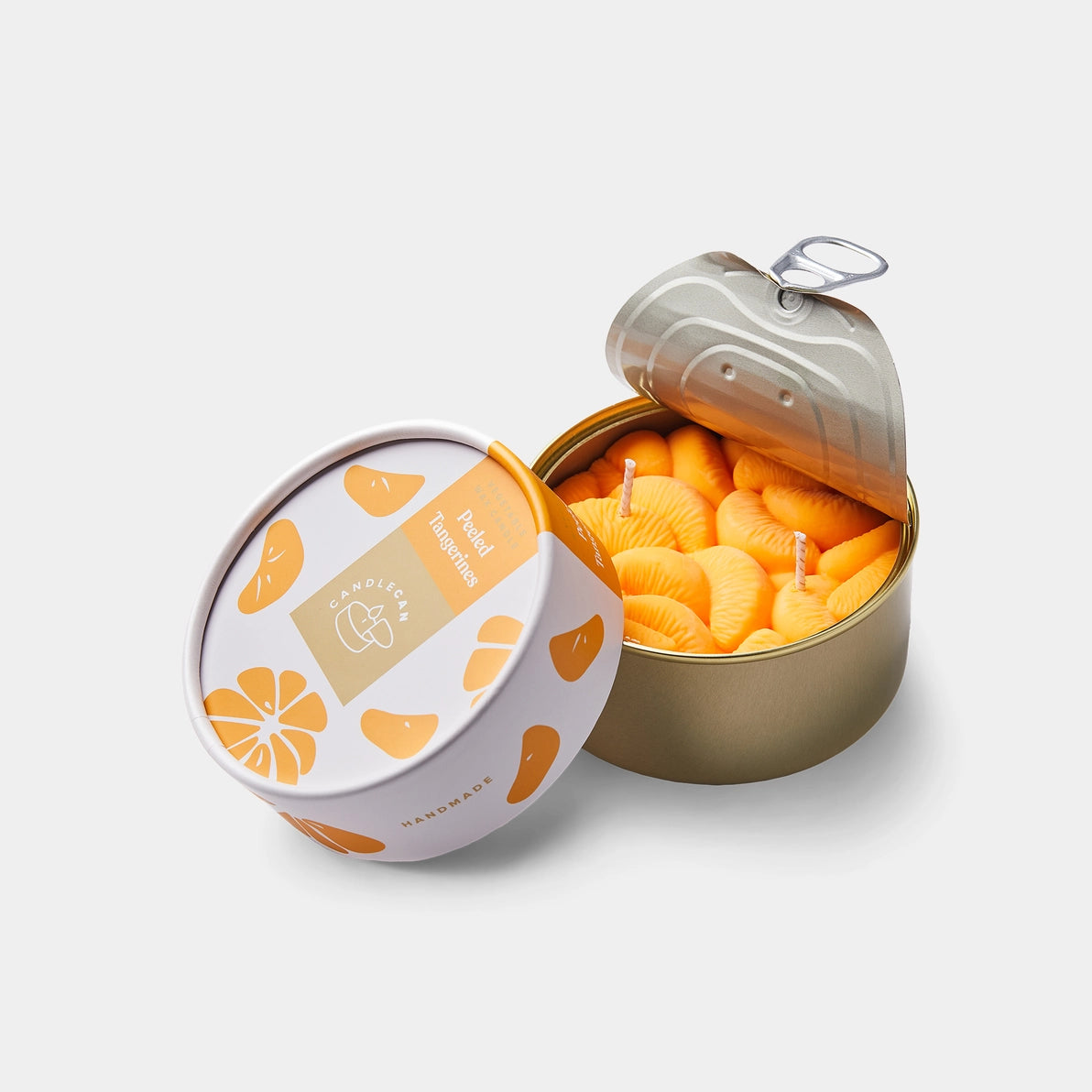 Top-down view of a tangerine-scented candle designed to look like peeled tangerine segments inside a tin can, made from bright orange wax with visible wicks.