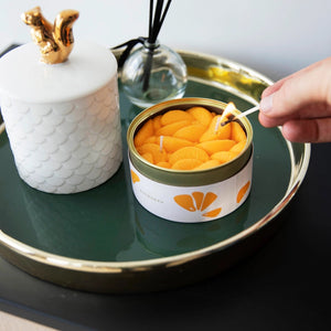 Open peeled tangerine candle tin styled on a breakfast table with real tangerines and orange juice, blending seamlessly with food items for a fun visual surprise.