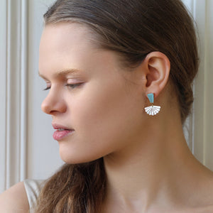 Side profile of woman wearing turquoise opal and mother of pearl statement earrings, showing the iridescent pearl fan drop sitting just below the earlobe.