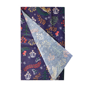 Unfolded Twilight Christmas Tissue Paper with one sheet partially opened, showcasing the full woodland animal and mushroom print in festive red, green, and cream tones.