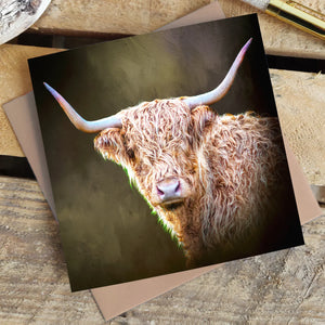 Twilight Highland Cow Blank Greetings Card resting on a rustic wooden surface, paired with a recycled kraft envelope.