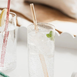 Amber twist straw in sparkling drink with mint garnish.