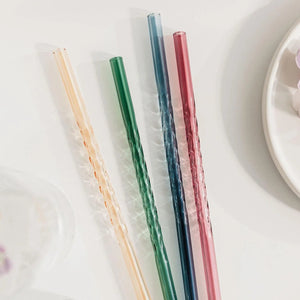 Pastel coloured twist straws arranged on white table.
