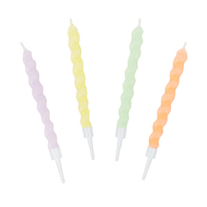 Set of four pastel twisted candles in yellow, pink, green and purple with holders.