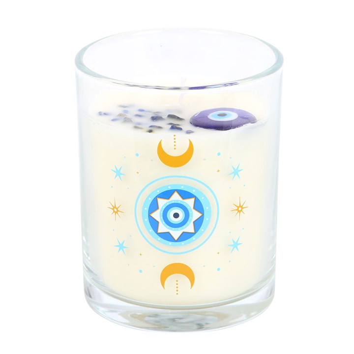 Close-up of white rose candle in glass jar with moons, stars, and protective eye design.