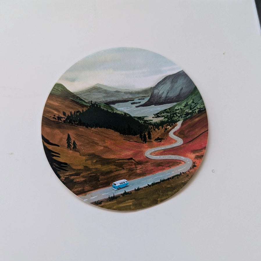 Close-up of the Up the Highlands vinyl sticker showing a scenic gouache illustration of a camper van driving along a winding road through the Scottish Highlands.