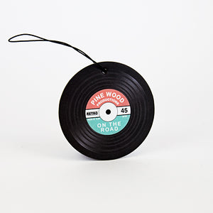Vinyl record-shaped pinewood-scented car air freshener on white background – retro design, perfect gift for music lovers.