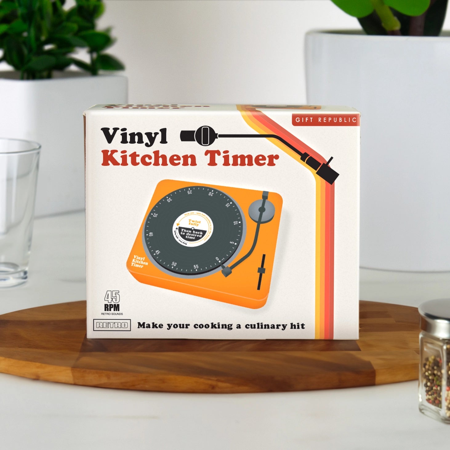 Retro Vinyl Kitchen Timer in packaging on a wooden board with plants in the background.