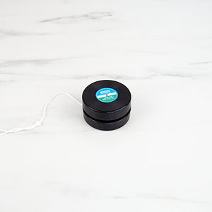 Black vinyl record design yoyo with string on white background.