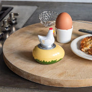 Chicken kitchen timer on wooden board with egg cup in breakfast setting