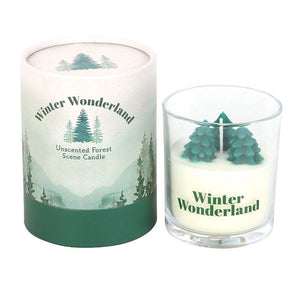 Winter Wonderland unscented candle with evergreen tree wax design in glass holder next to decorative forest scene packaging.