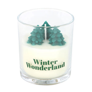 Close-up of Winter Wonderland candle in clear glass jar featuring miniature tree wax design and festive lettering.