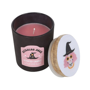 Side view of Witching Hour candle in matte black glass jar with pink wax and removable illustrated wooden lid, featuring plum and black cherry scent.