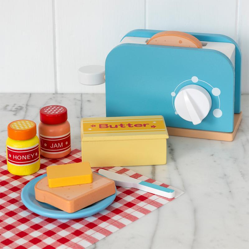 Wooden toy toaster playset with breakfast accessories on red gingham cloth
