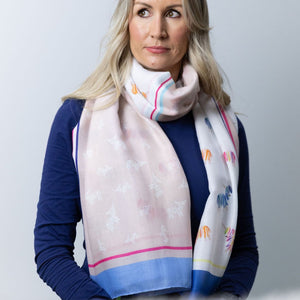 Model wearing the Woolly Ewe Scarf - Pebble, featuring a soft neutral base with vibrant ewe pattern.