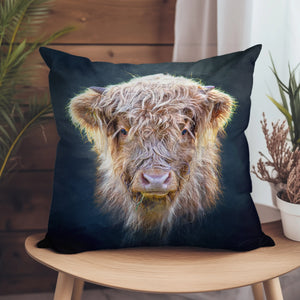 Little Highlander Highland Cow Suede Cushion on a wooden chair, featuring a detailed close-up of a fluffy Highland cow with soft faux suede fabric.