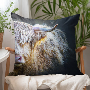 A soft vegan-suede cushion with a striking Highland cow portrait, styled in a cosy home setting.