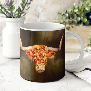 Wraptious Rusty Rebel Ceramic Mug featuring a detailed Highland cow design by Gary Cox, displayed on a white kitchen counter with plants in the background.