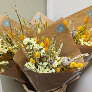 Front-facing Yellow Dried Flower Arrangement wrapped in kraft paper.