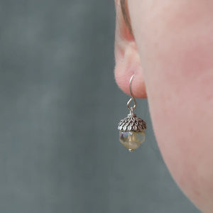 Yellow Opal Acorn Earrings worn on an ear, showcasing their delicate size and design