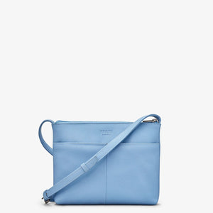 Back view: Rear of the Yoshi blue leather crossbody bag showing slip pocket and smooth finish.