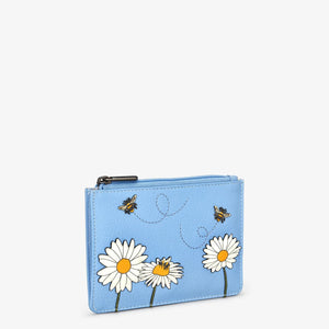 Angled view of slim blue leather purse with daisy and bumblebee appliqué and visible zip closure.