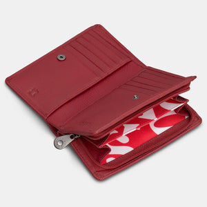 Angled view of cherry red leather purse partially open, displaying card slots and inner zipped compartment.