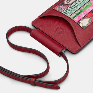 Flat lay of red leather crossbody phone case with strap extended and close-up on book design.