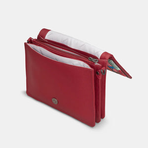 Top-down view of inside compartments of red crossbody bag with zip and slip sections.