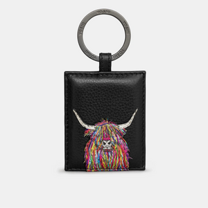 A black leather keyring featuring a vibrant multicolour Highland cow design with intricate stitching. The keyring has a sturdy metal ring engraved with the “Yoshi” brand name, offering a secure and stylish way to carry keys or attach to bags.