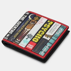 Angled standing view of Yoshi Horror Bookworm Wallet highlighting detailed horror book spine appliques on red leather background.
