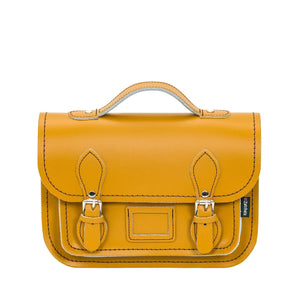 Leather satchel in yellow. This image shows the top handle and the buckle closers. 