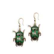 Pair of Antique Beetle Drop Earrings in green enamel and antique gold on white background.
