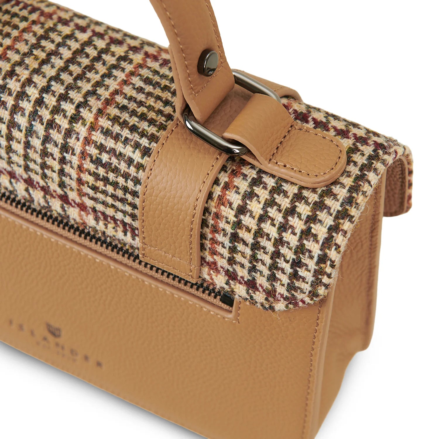 Close-up of beige leather handle and Harris Tweed dogtooth fabric detail.