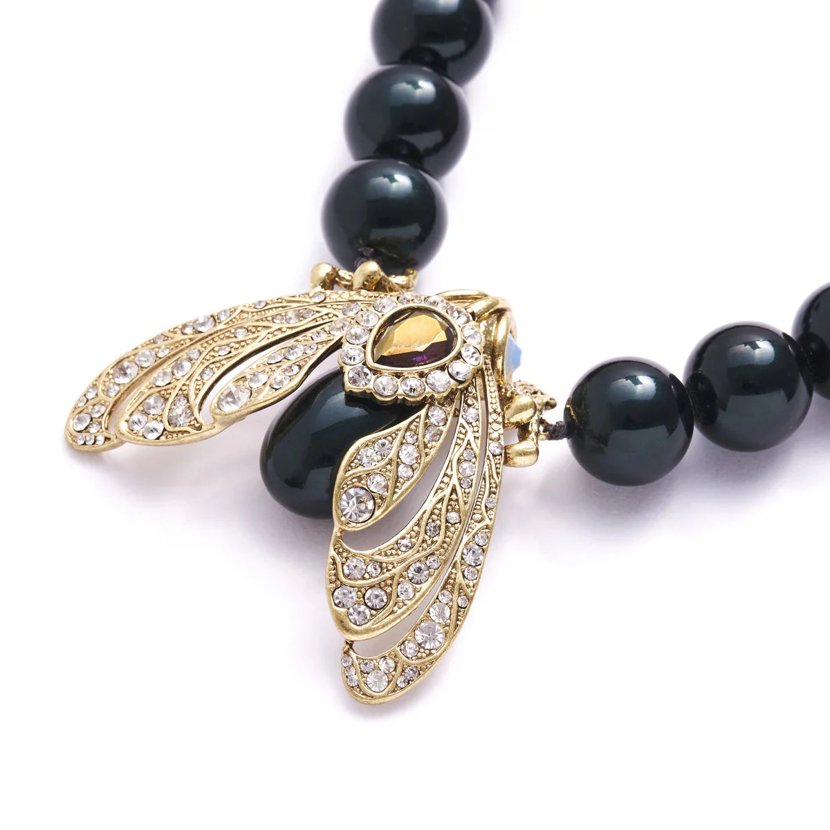 Detailed side view of Bill Skinner Moth Necklace showing antique gold plating, crystal wings, and Tahitian pearl accents.
